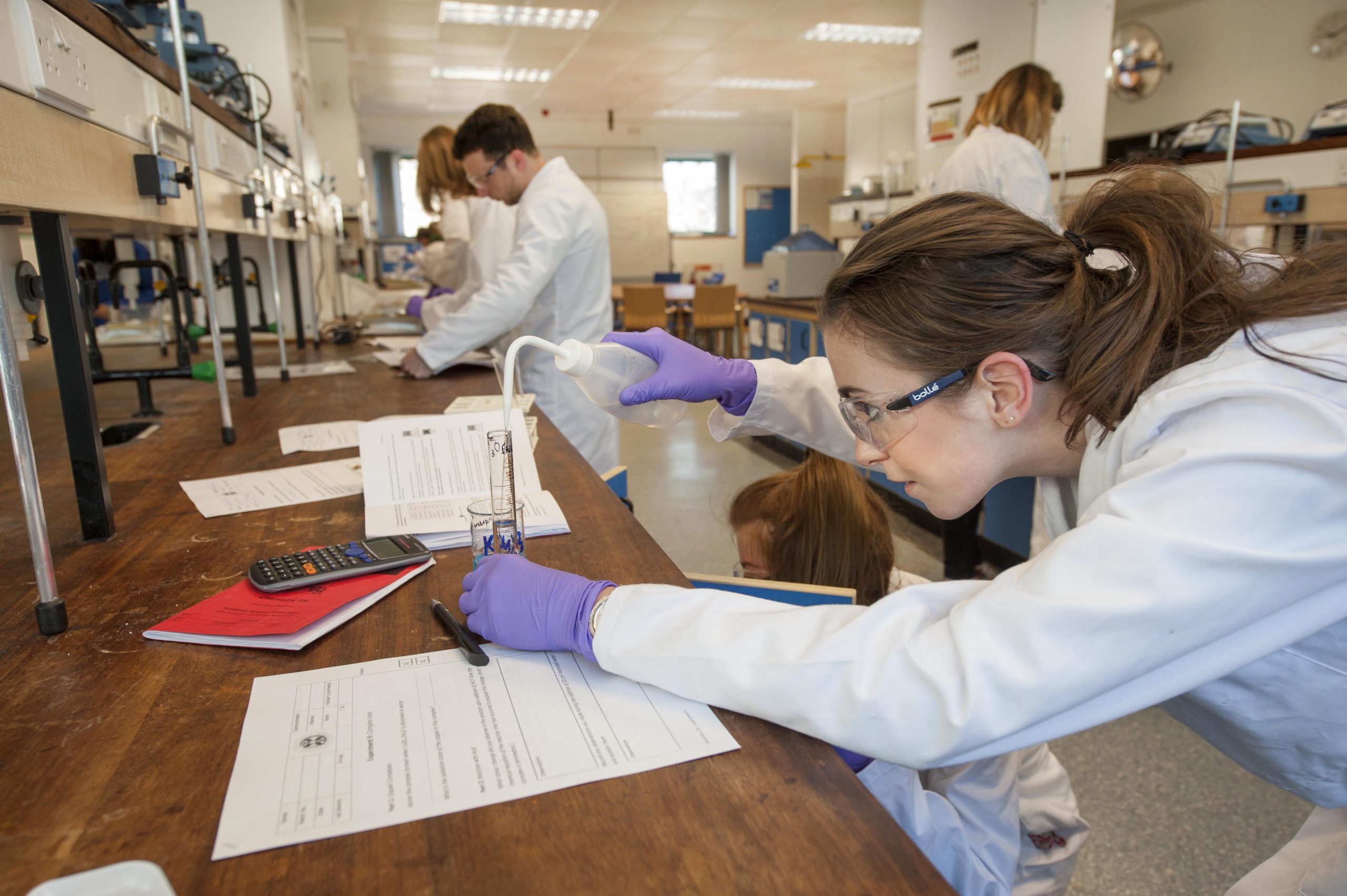 Photo of chemistry students in the lab doing a practical class.