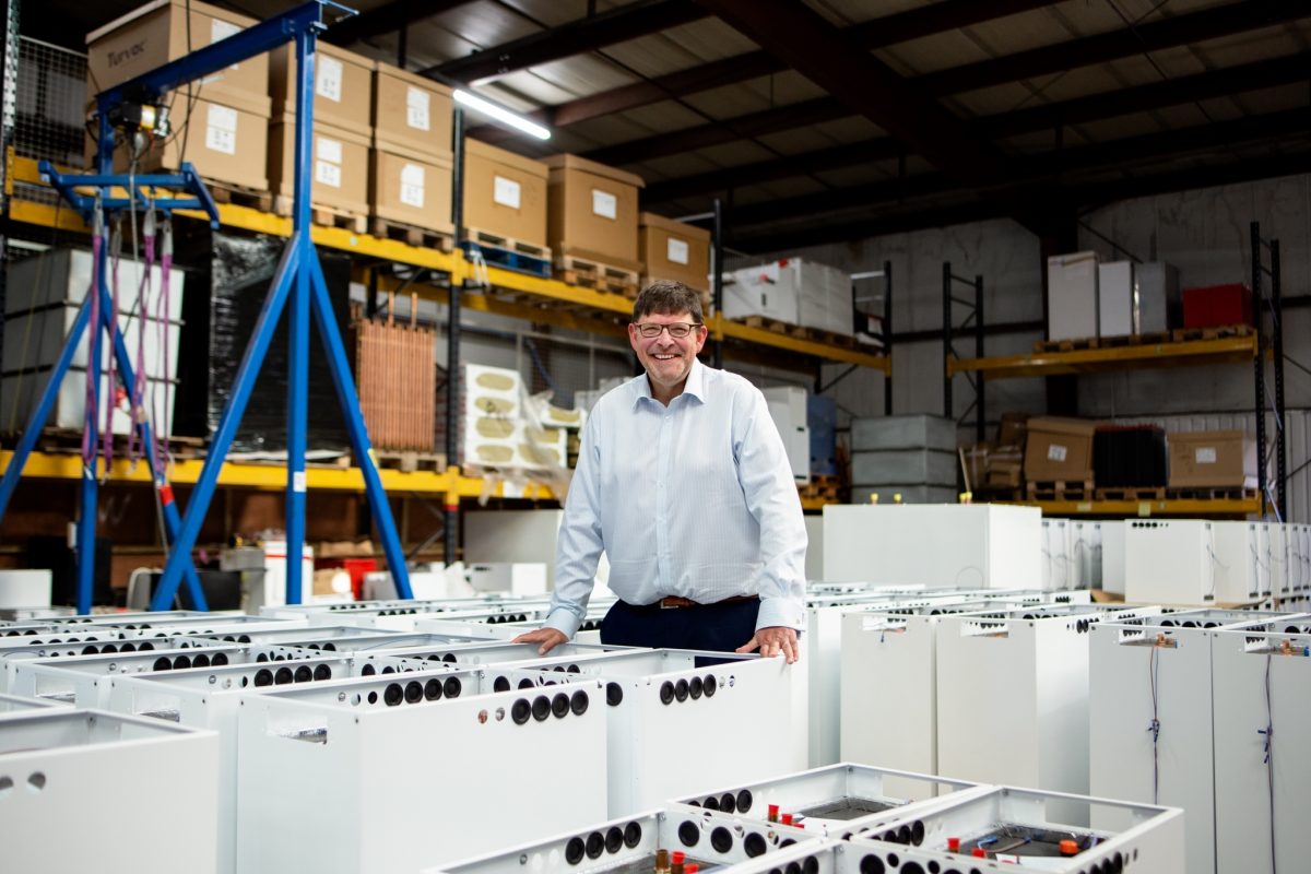 Sunamp founder Andrew Bissell stands in the Sunamp factory surrounded by heat batteries in production.